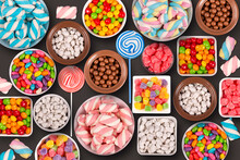 Colorful candies, marshmellows, chocolate balls in jars, lollipops and sweet peanuts