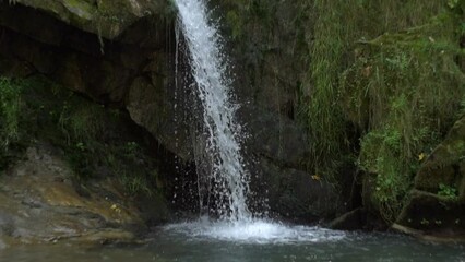 Wall Mural - Water falls from stones. A small waterfall