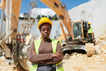 Young Confident Black Woman In Workwear And Protective Helmet Standing With Her Arms Crossed On Chest And Looking At Camera