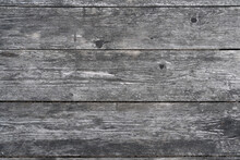 Fragment Of A Wall Made Of Old Unpainted Boards. From Time And Weather, The Surface Of The Wood Has Become Gray And Textured. Background.