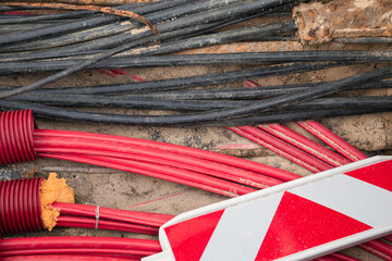 Network cables in red corrugated pipe are buried underground on the street. underground electric cable infrastructure installation. Construction site with A lot of communication Cables