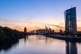 Fototapeta  - Europäische Zentralbank mit Frankfurter Skyline während des Sonnenuntergangs