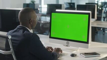 Business African-American Man Working Internet on Computer On Desk. Man Surfing on PC with Green Screen Notebook. Close Up Male Freelancer Searches For Information on The Internet