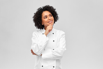 cooking, culinary and people concept - happy smiling female chef in white jacket over grey background