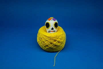 Mexican skull amigurumi on yellow ball of yarn