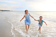 © zilvergolf - Happy Asian young sister and little brother having fun running together on tropical sand beach at sunrise. Happy family boy and girl enjoy in summer holiday.