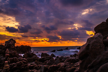 Wall Mural - rocks on the coast at sunset with purpple clouds and orange sky in puerto escondido oaxaca 