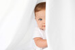 © Lisa Tichané - Blue-eyed baby peeking behind white curtain