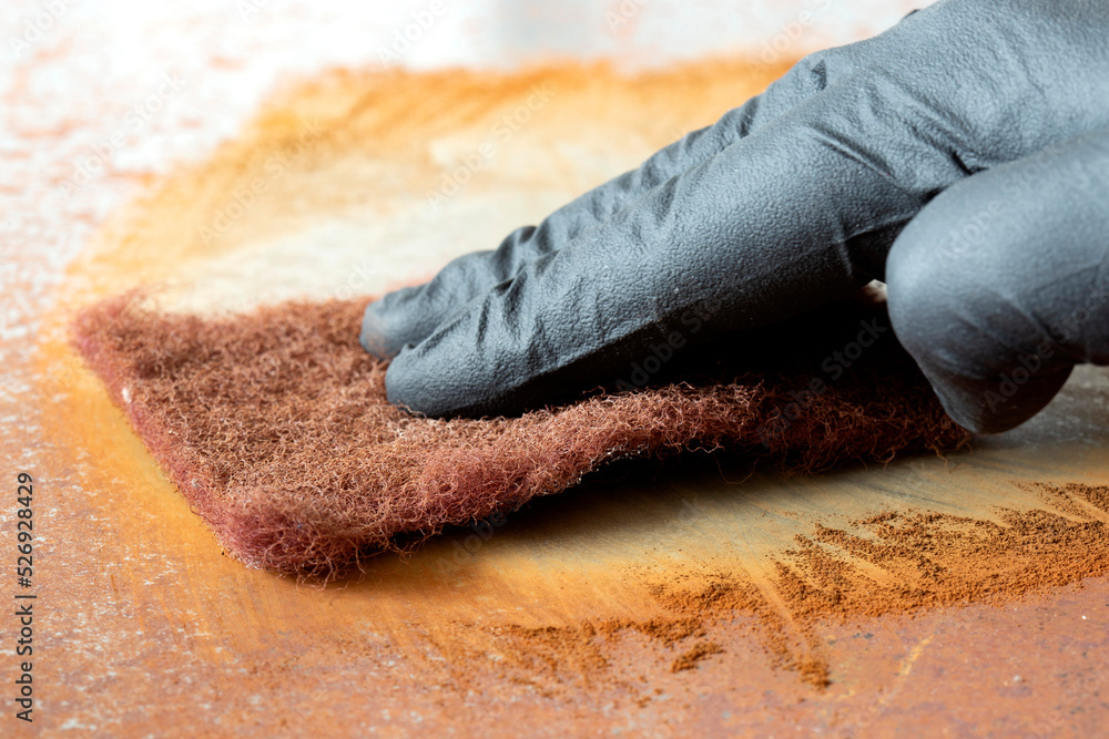Rust Removing Pad Rubbing rust off sheet steel with an abrasive pad. Restoration project ...