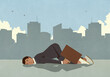 © fStop - Exhausted businessman sleeping on city sidewalk