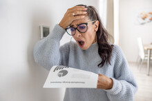 Woman is shocked from the rising energy costs and the bill she received for heat and electricity for her household