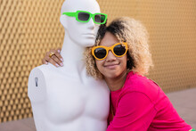 Smiling Woman Wearing Sunglasses Hugging Mannequin