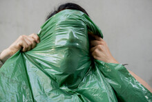 Man Covering Face With Green Plastic