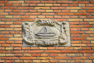 Old sign of a ship on a brick wall