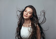 © millaf (Nemchinova) - Young woman with beautiful long blowing windy wavy hair on grey background