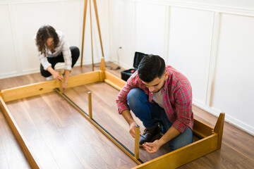 Wall Mural - Handy man and woman building a self assembly bed frame