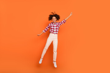 Sticker - Full length body size view of attractive cheerful girl jumping holding copy space isolated on bright orange color background