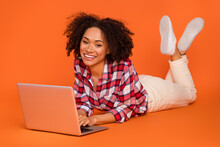 Portrait Of Attractive Cheery Girl Lying Using Laptop Ui Web Study Education Isolated On Bright Orange Color Background