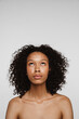 © Drobot Dean - Shirtless black woman looking upward while posing on camera
