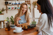 © Drobot Dean - White young women playing chess while drinking tea in cafe