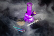 Purple glass bong with joint and a lot of thick white smoke. Top view marijuana weed addiction concept.
