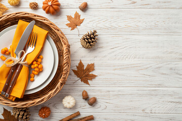 Thanksgiving day concept. Top view photo of rattan tray plate knife fork napkin rowan maple leaves pine cones acorns small pumpkins cinnamon on isolated white wooden table background with copyspace