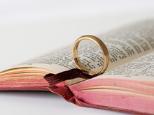 Gold Wedding Ring On Open Bible