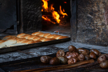 Tray with empanadas, typical Peruvian food, in the background the clay oven with the flame burning, in the city of Pisac, in Peru. 