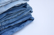 © iama_sing - Lots of jeans pants in a stack. Denim background.