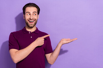 Wall Mural - Photo of impressed young brunet guy hold index look empty space wear violet t-shirt isolated on purple color background