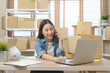 © Pormezz - Young Asian woman owner of small online store packing customer orders in the home office.