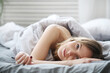 © racool_studio - Picture of young woman lying on linen in bed and looks at camera at home