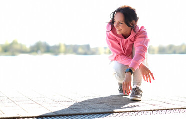 Wall Mural - Young beautiful girl in sportswear stretches outdoor