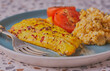 Smoked haddock fillet with scrambled egg and tomatoes.