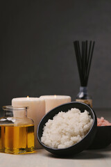 Sea salt with a glass jar of oil and two candles for cosmetologic procedures