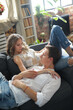 © racool_studio - Photoshoot of a young couple of woman and man spending time together on sofa