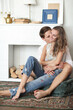 © racool_studio - Young, in love, beautiful couple sitting hugging on the floor in front of an unlocked fireplace
