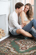 © racool_studio - Young, in love, beautiful couple sitting hugging on the floor in front of an unlocked fireplace