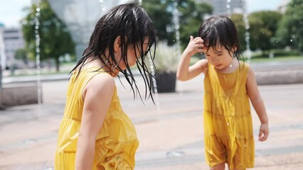 Poster - 駅前広場の噴水で水浴びして遊んでいる女の子