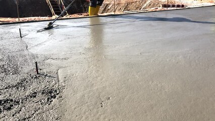 Wall Mural - Construction worker uses trowel to level cement mortar screed. Concrete works on construction site. Cast-in-place work using trowels