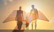 © kieferpix - Family worship concept.Silhouette of family walking together and hand holding bible.