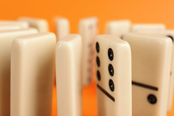 Sticker - White domino tiles with black pips on orange background, closeup