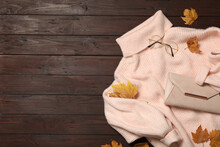 Warm Sweater, Bag And Dry Leaves On Brown Wooden Background, Flat Lay With Space For Text. Autumn Season