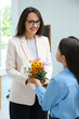 © New Africa - Schoolgirl congratulating her pedagogue with bouquet in classroom. Teacher's day
