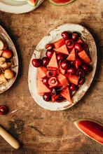A Fresh Fruit Salad Made From Cherries And Water Melon On A Rustic Plate