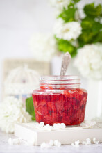 A Jar Of Strawberry Compote For Desserts In A Light And Bright Setting.