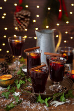Various Vintage Glasses Holding Mulled Wine In A Festive Setting With Ivy And Fairry Lights.