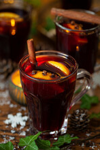 A Glass Of Mulled Wine With Orange, Clove And Cinnamon Stick Garnishes.
