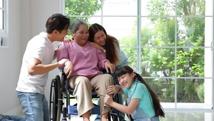 Wall Mural - Happy asian family father, mother and daughter take good care of grandmother, They are smiling and laughing together at new house on moving day.