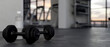 © bongkarn - close-up, Dumbbells and a bottle of water on a black gym floor over blurred fitness background